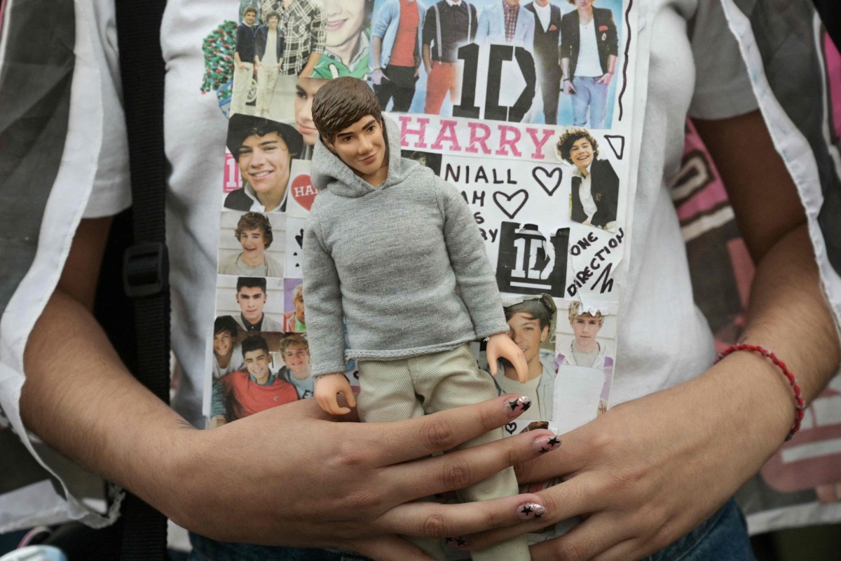 A fan holds a doll looking like the late British singer Liam Payne as she attends to pay tribute at the Obelisco in Buenos Aires on October 17, 2024. Photo by JUAN MABROMATA / AFP