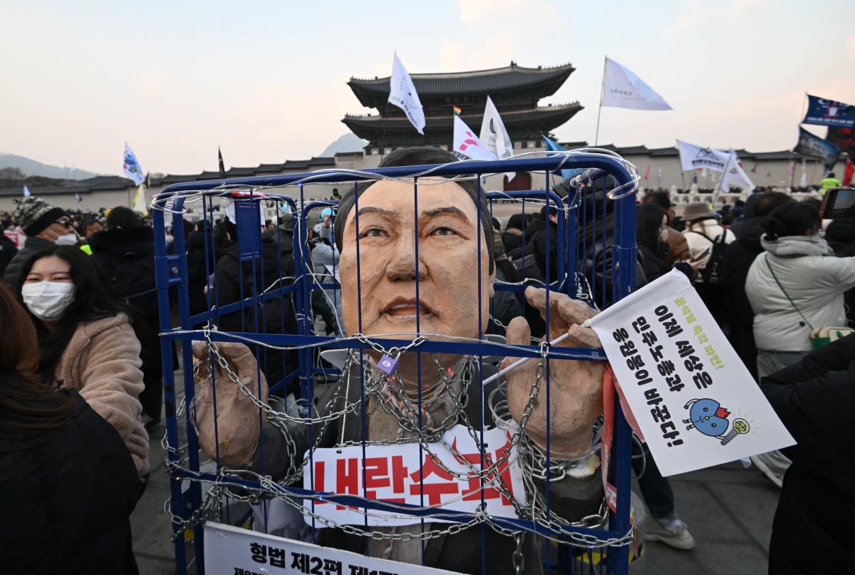 An effigy of South Korea's impeached President Yoon Suk Yeol is seen in a mock prison as protesters take part in a rally calling for Yoon's ouster in front of the Gwanghwamun Gate of Gyeongbokgung Palace in Seoul on December 21, 2024. Photo by Jung Yeon-je / AFP.