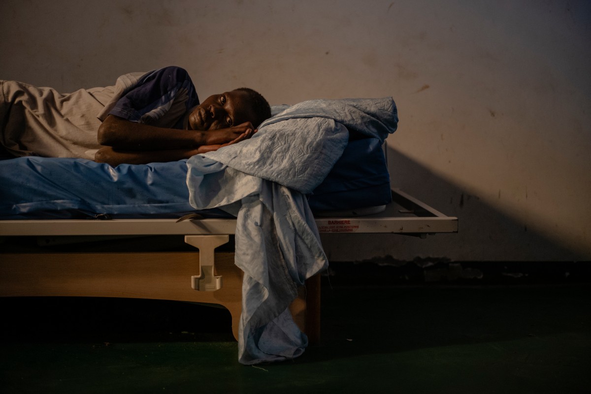 A young man rests on the bed of his room at the psychiatry centre of the CHS hospital in Nouakchott, December 12, 2024. Photo by MICHELE CATTANI / AFP.