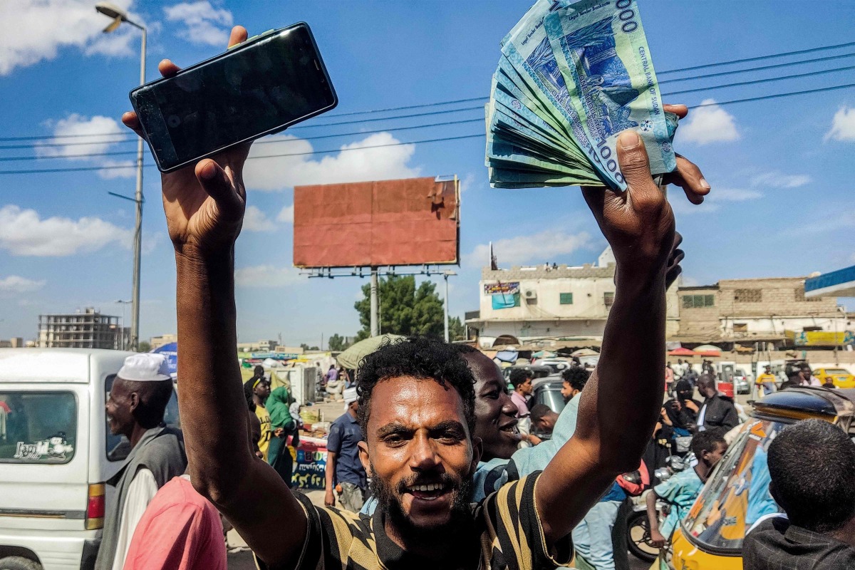 People protest calling upon the army-backed Sudanese government to extend the deadline to exchange Sudanese pound banknotes after authorities reportedly changed two of the notes in circulation, invalidating the old ones, in the northeastern Red Sea city of Port Sudan on December 31, 2024. (Photo by AFP)
