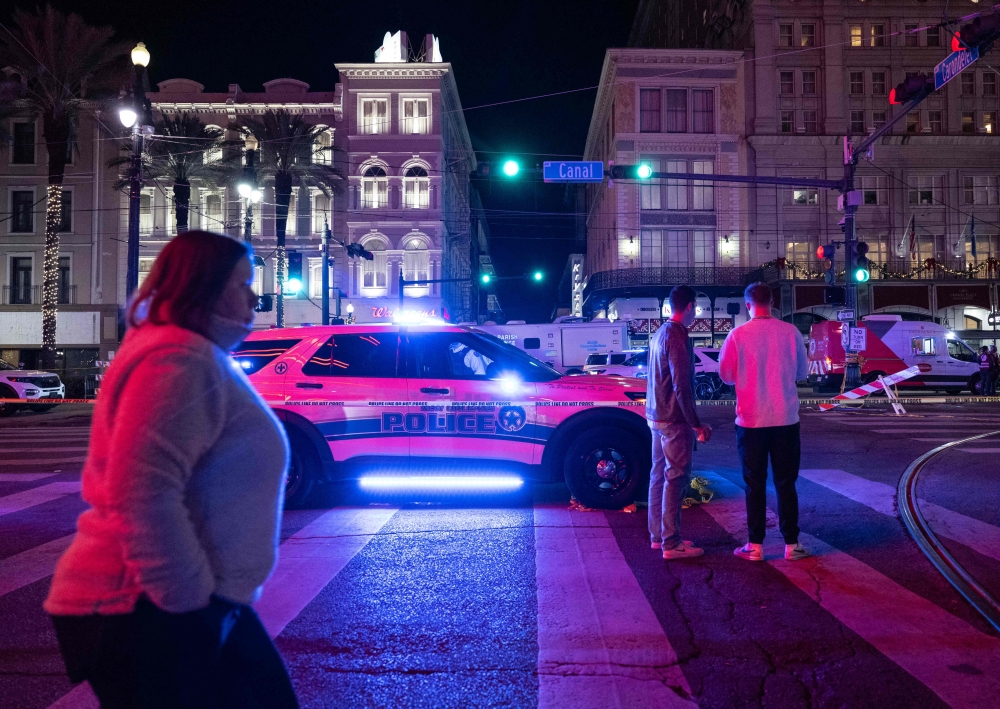 People look at a blocked off road from Canal Street after at least 15 people were killed on Bourbon Street, after an attack early in the morning, on January 1, 2025 in New Orleans, Louisiana.  (Photo by Andrew Caballero-Reynolds / AFP)