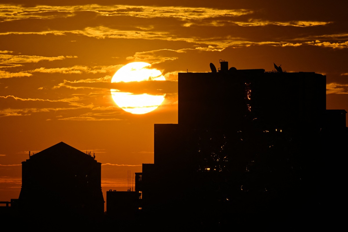 The sun rises behind high-rise buildings in Beijing on September 6, 2024. Photo by ADEK BERRY / AFP