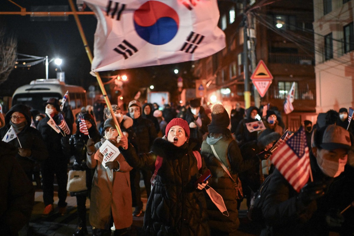 A woman waves South Korea's flag during a rally to support South Korea's impeached president Yoon Suk Yeol near the presidential residence in Seoul on January 2, 2025. Photo by Philip FONG / AFP