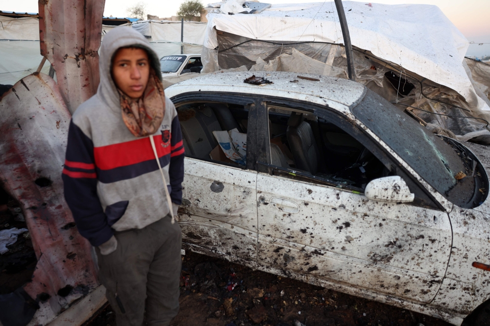 A displaced Palestinian boy stands amid the destruction following an overnight Israeli strike on a makeshift displacement camp in Mawasi Khan Yunis in the southern Gaza Strip on January 2, 2025. (Photo by Bashar Taleb / AFP)