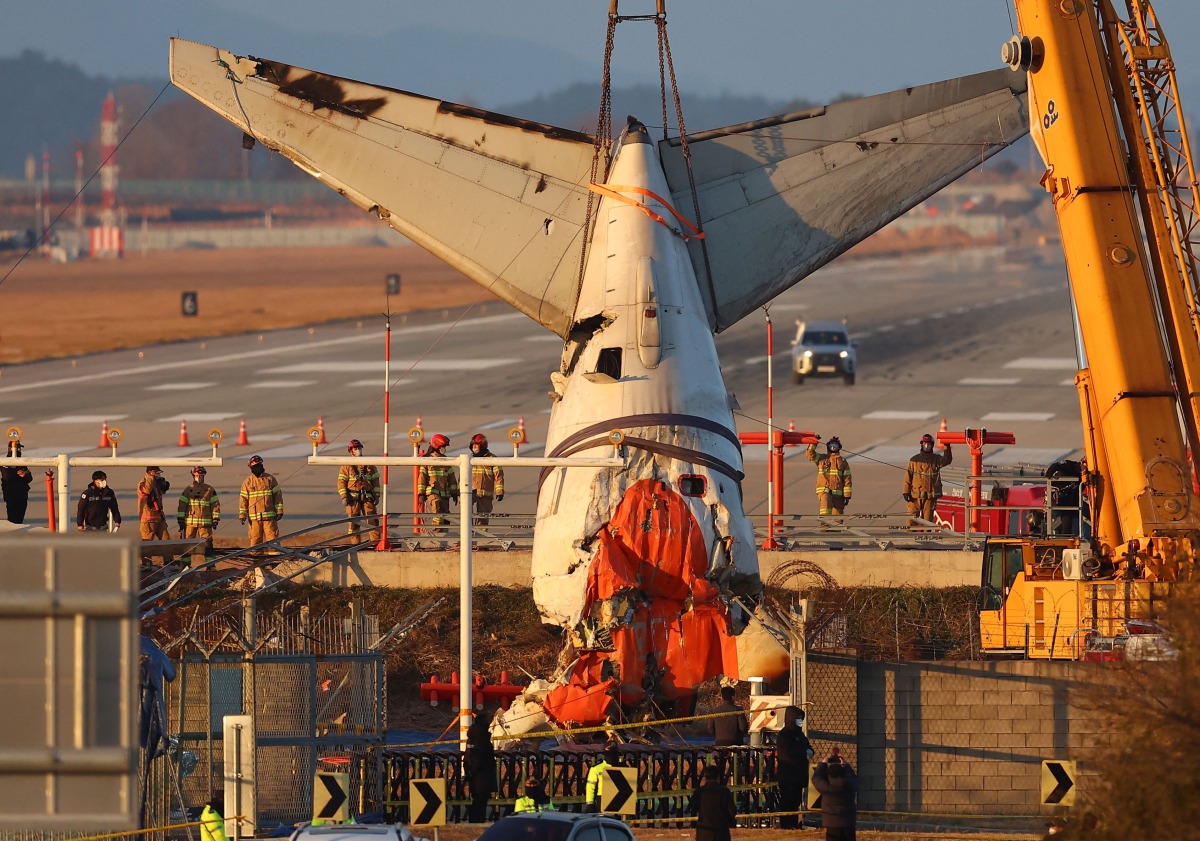 A crane lifts the tail section during the salvage operation of the Jeju Air Boeing 737-800 aircraft which crashed and burst into flames at Muan International Airport, in Muan on January 3, 2025. Photo by YONHAP / AFP