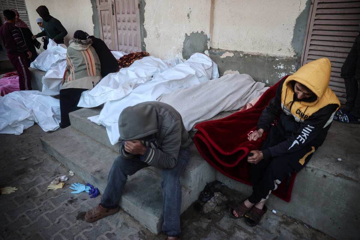 Palestinians mourn over the bodies of relatives killed in an Israeli strike, outside a hospital in Deir el-Balah in the central Gaza Strip on January 3, 2025. Photo by Eyad BABA / AFP.