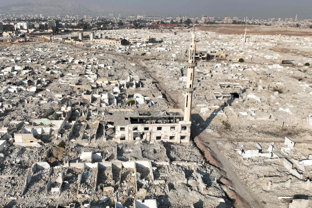 An aerial view shows the destruction in the Damascus district of Assali on January 2, 2025. (Photo by Bakr Alkasem / AFP)