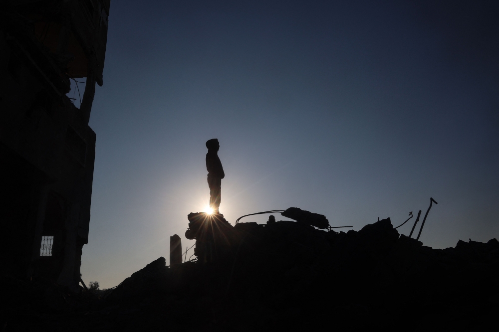 A young Palestinian stands amid the destruction in the aftermath of an Israeli strike in the al-Maghazi refugee camp in the central Gaza Strip on January 3, 2025. (Photo by Eyad Baba / AFP)