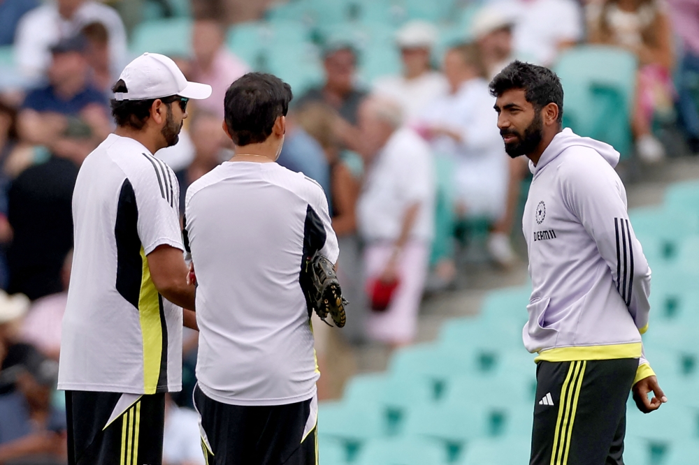 India's Rohit Sharma (L) and Jasprit Bumrah (R) talk with team coach Gautam Gambhir before the start of day one of the fifth Test match between Australia and India at The SCG in Sydney on January 3, 2025. (Photo by David Gray / AFP) 