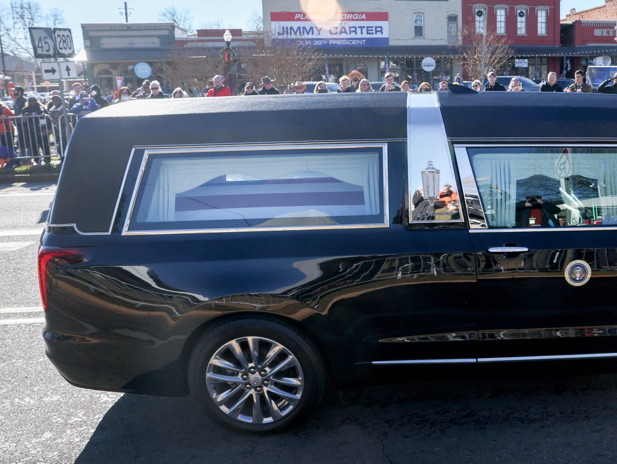 The hearse carrying President Jimmy Carter's flag draped casket passes near the main street of Carter's hometown on January 04, 2025, in Plains, Georgia. (Photo by JOE RAEDLE / GETTY IMAGES NORTH AMERICA / Getty Images via AFP)