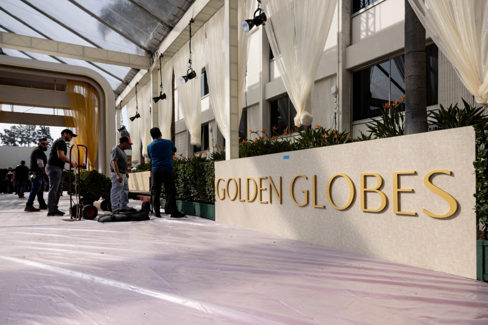 Workers display hedges by the red carpet as technicians and workers add the last touches the day before the Golden Globes at Beverly Hilton in Beverly Hills, California, on January 4, 2025. (Photo by Etienne Laurent / AFP)