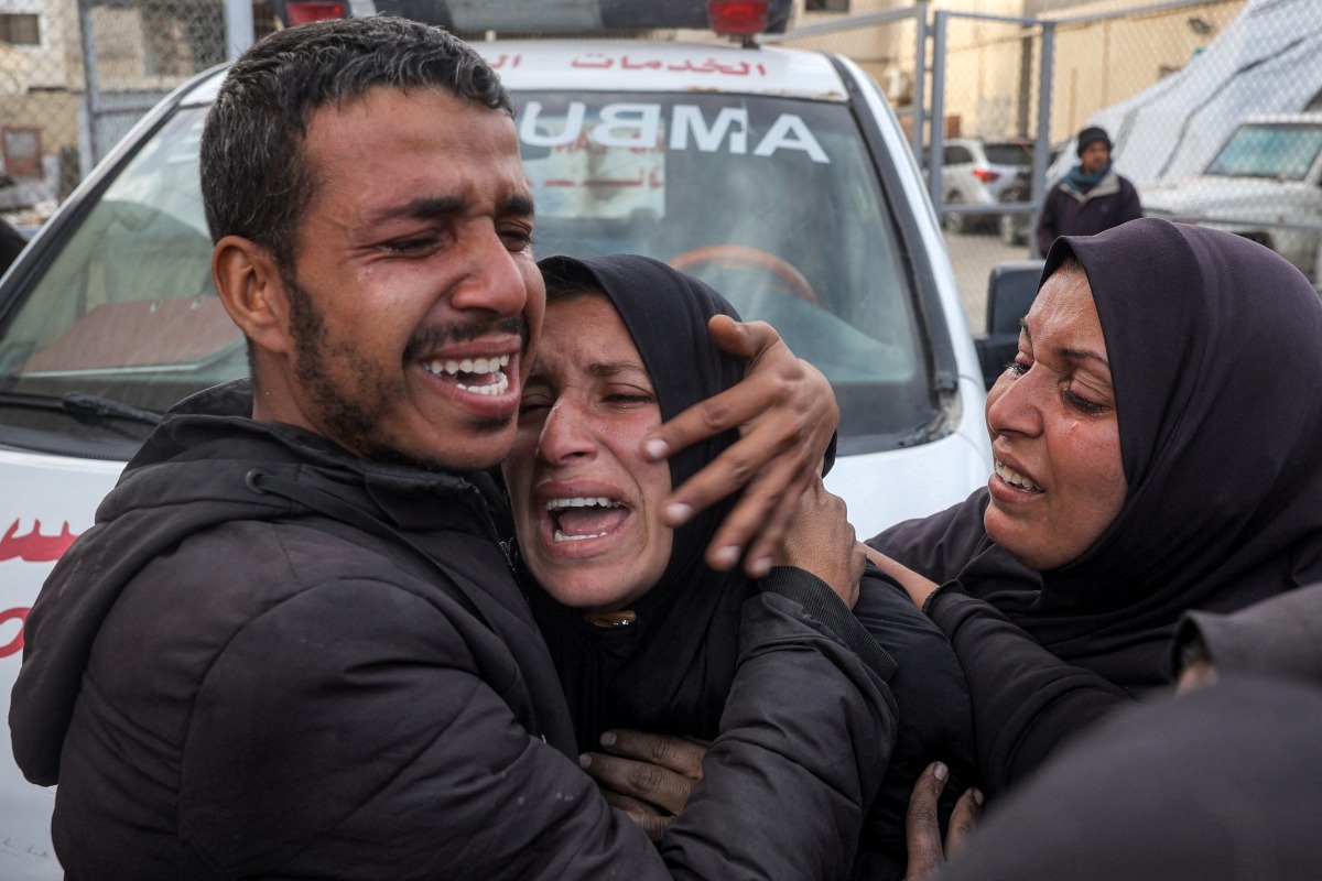 A woman mourns her relatives who were killed by Israeli bombardment outside the Aqsa Martyrs hospital in Deir el-Balah in the central Gaza Strip on January 5, 2025. Photo by Eyad BABA / AFP.
