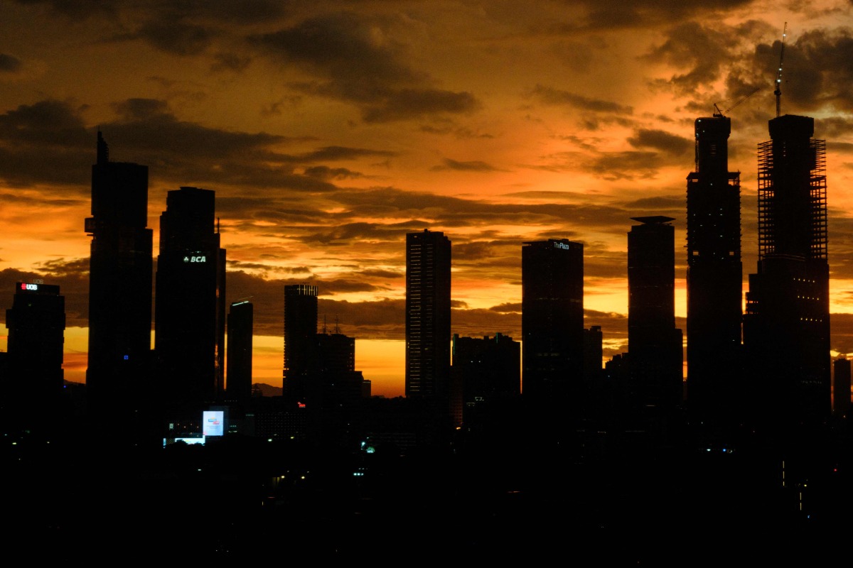 Buildings are seen during sunset in Jakarta on January 5, 2025. (Photo by Yasuyoshi CHIBA / AFP)