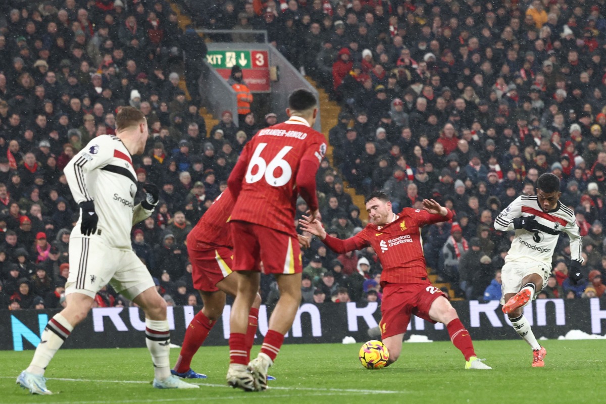 Manchester United's Ivorian midfielder #16 Amad Diallo (R) shoots to score their second goal during the English Premier League football match between Liverpool and Manchester United at Anfield in Liverpool, north west England on January 5, 2025. (Photo by Darren Staples / AFP) 