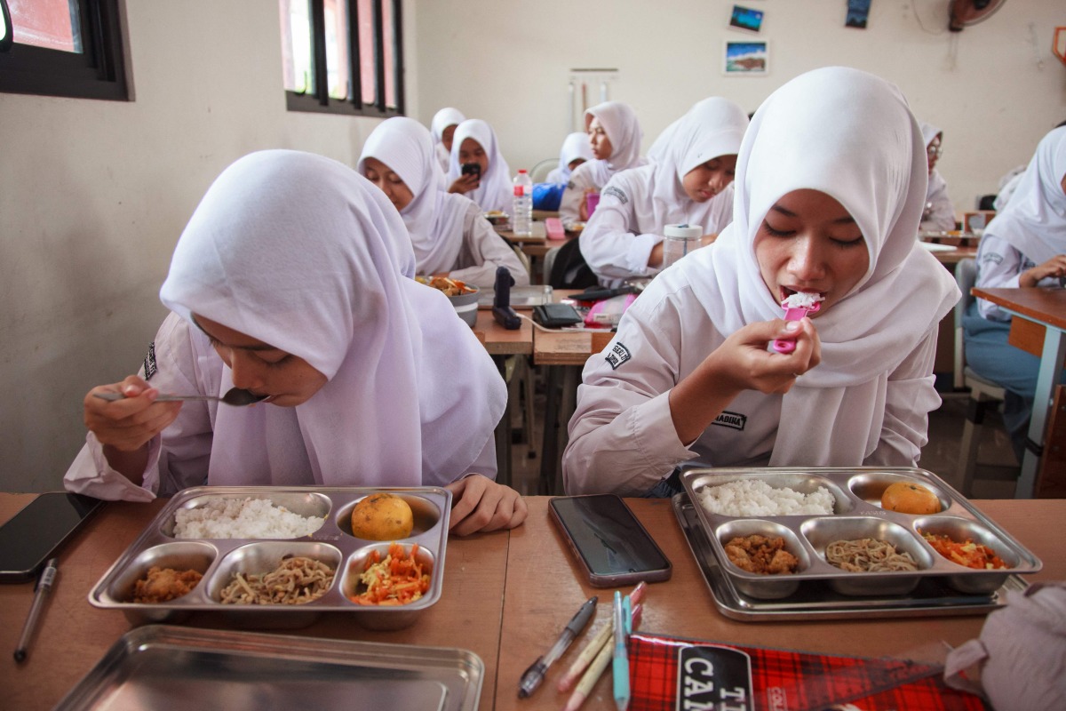 Students eat lunch on the first day of a free-meal program at 11 State Senior High School in East Jakarta on January 6, 2025. Photo by Aditya IRAWAN / AFP