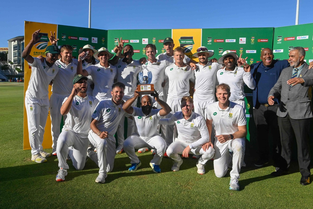 South Africa's Temba Bavuma (C) holds up the trophy after winning the Test match series, following the fourth day of the second international Test cricket match between South Africa and Pakistan, at Newlands stadium in Cape Town on January 6, 2025. (Photo by Rodger Bosch / AFP)