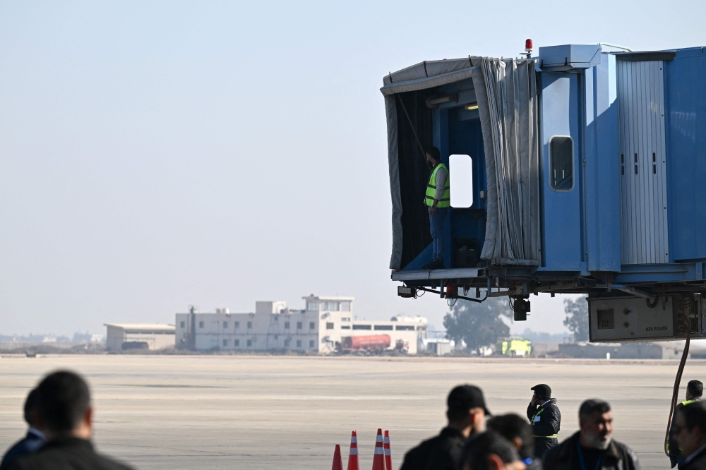 Airport workers wait for the arrival of an international flight at the Damascus International Airport on January 7, 2025. (Photo by Louai Beshara / AFP)
 