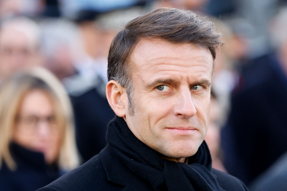 France's President Emmanuel Macron looks on as he takes part in a wreath-laying ceremony to pay tribute to Ahmed Merabet, a Muslim police officer guarding the offices who was executed at point-blank range, as part of marking 10 years since an attack on the Charlie Hebdo satirical newspaper, on January 7, 2025.  (Photo by Ludovic Marin  / AFP) 