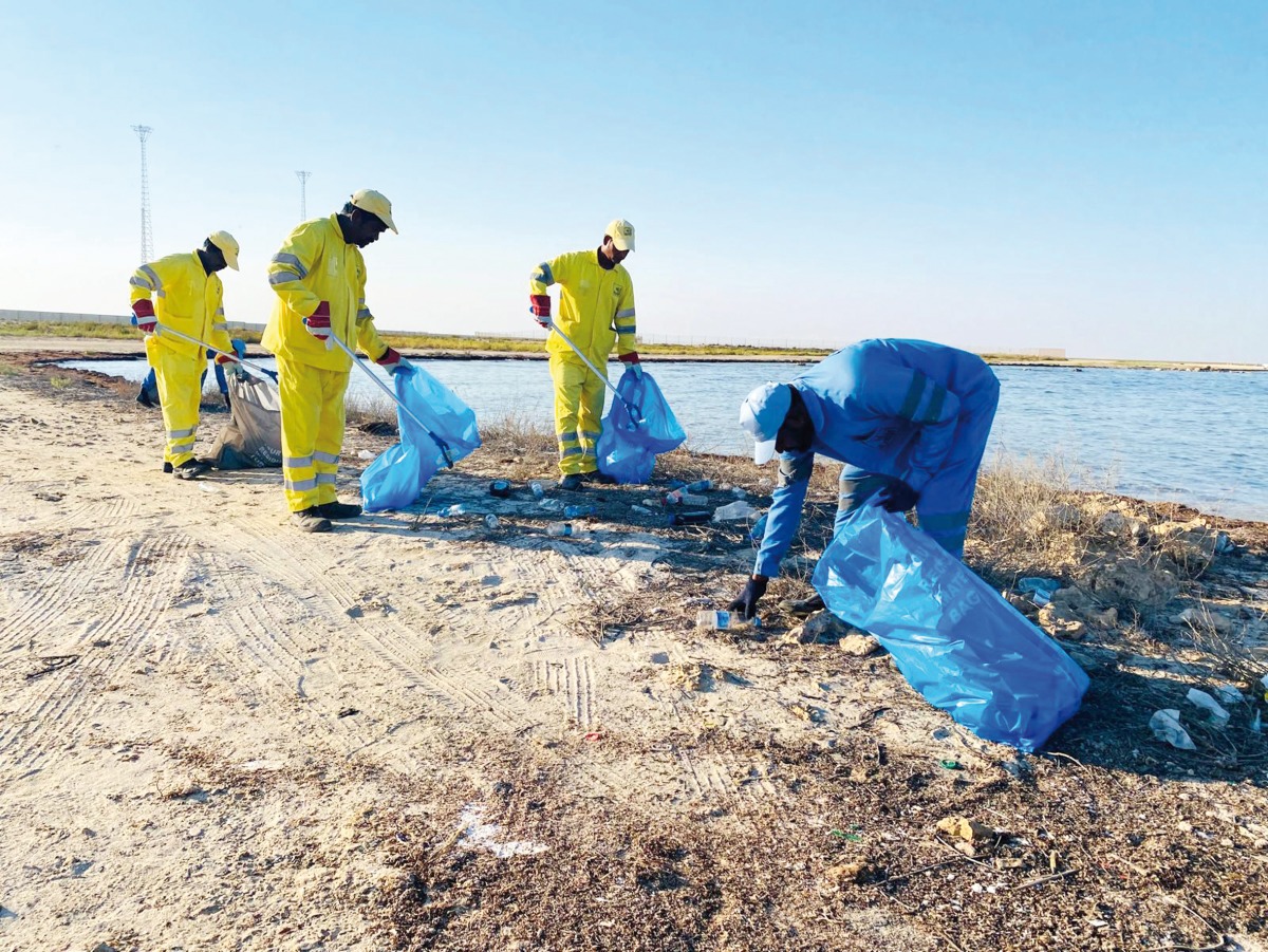 Municipality staff clean a beach. 