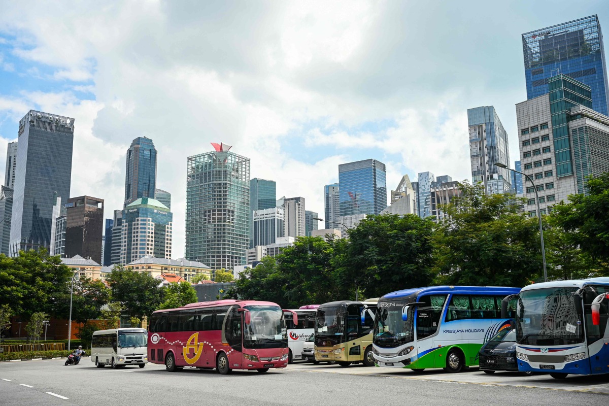 Tourist buses are parked at an open carpark near the Chinatown district in Singapore on January 7, 2025. (Photo by Roslan RAHMAN and ROSLAN RAHMAN / AFP)