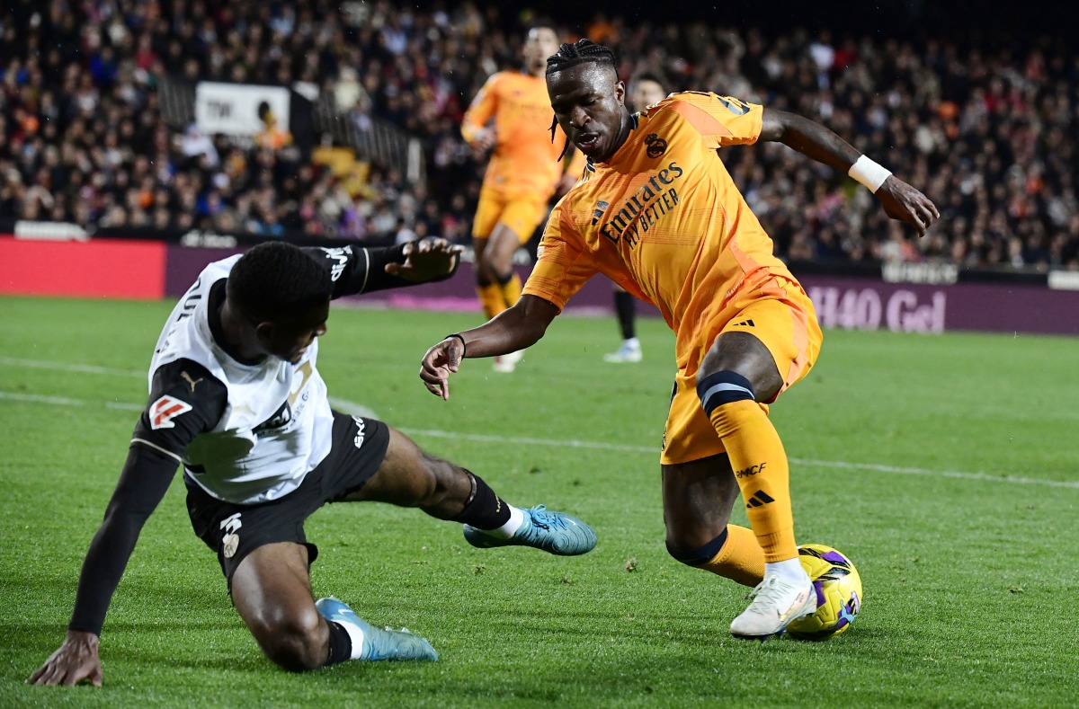 Valencia's Spanish defender #03 Cristhian Mosquera challenges Real Madrid's Brazilian forward #07 Vinicius Junior (R) during the Spanish league football match between Valencia CF and Real Madrid CF at the Mestalla stadium in Valencia on January 3, 2025. (Photo by JOSE JORDAN / AFP)