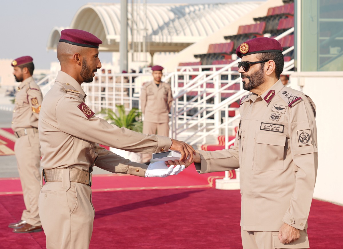 Commander of the Amiri Guard Lt. Gen. Staff Hazza bin Khalil Al Shahwani honouring one of the top graduating students at the event.