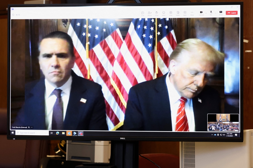 Todd Blanche, attorney for former US President Donald Trump, and US President-elect Donald Trump are seen on the screen at Manhattan criminal court in New York, on January 10, 2025. (Photo by Brendan McDermid / POOL / AFP)