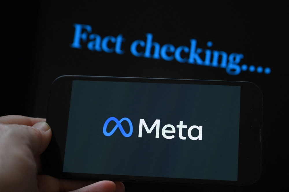 (Files) This photo illustration created on January 8, 2025, in Brussels, shows the media giant Meta's logo displayed on a smartphone and screen displaying the words 