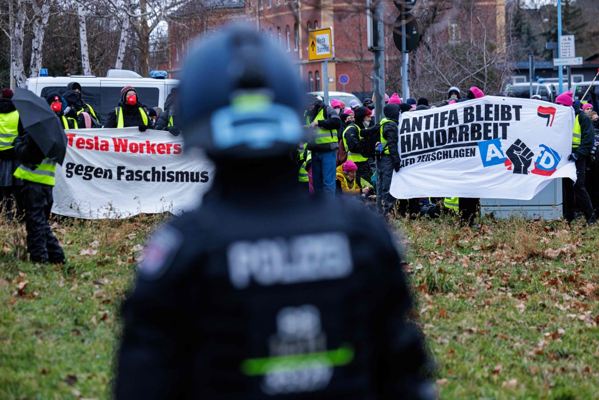 Demonstrators protesting against Germany's far-right Alternative for Germany (AfD) party hold banners reading 