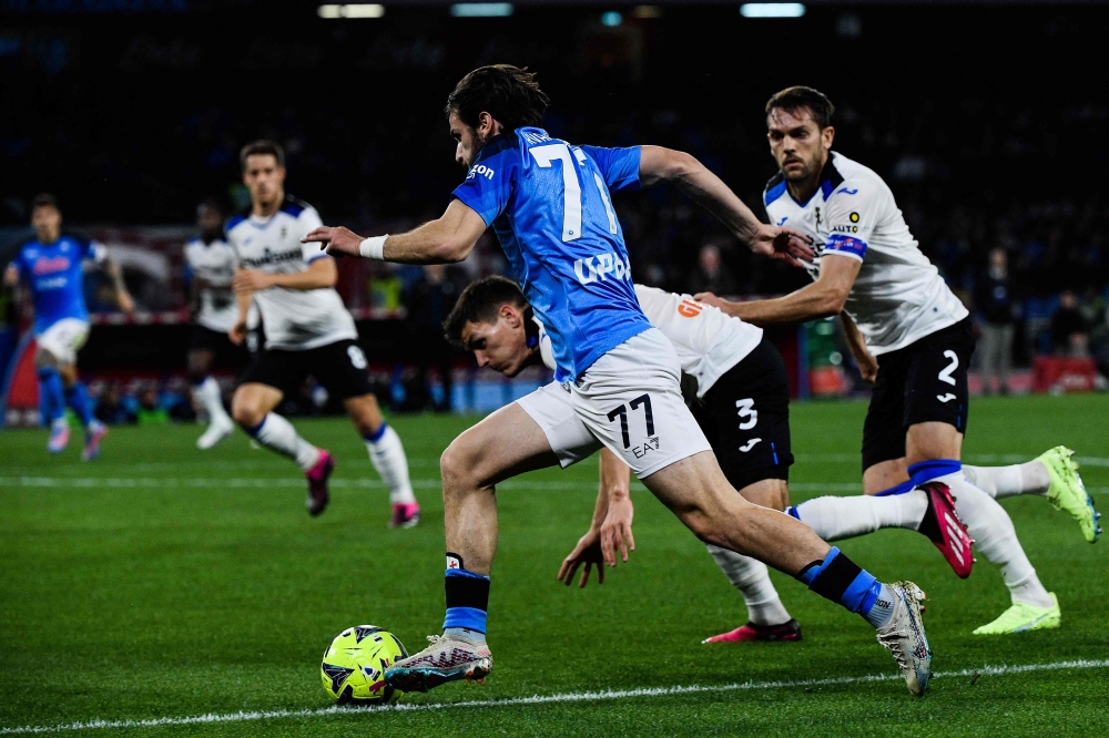 Napoli's Georgian forward Khvicha Kvaratskhelia (centre) outflanks Atalanta's Danish defender Joakim Maehle (rear centre) and Atalanta's Italian defender Rafael Toloi (right) during the Italian Serie A football match between Napoli and Atalanta on March 11, 2023 at the Diego-Maradona stadium in Naples. (Photo by Filippo MONTEFORTE / AFP)

