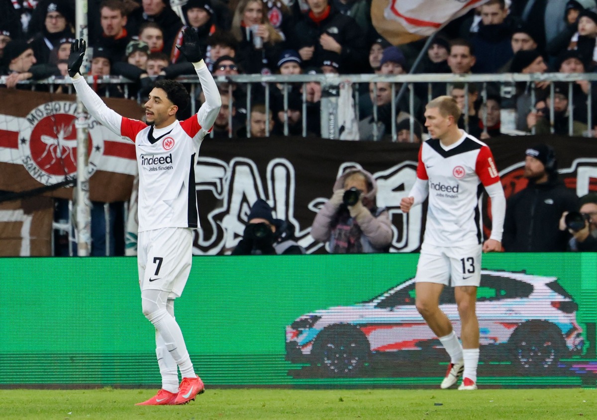 Frankfurt's Egyptian forward #07 Omar Marmoush (L) celebrates scoring during the German first division Bundesliga football match between St Pauli and Eintracht Frankfurt in Hamburg on January 11, 2025. (Photo by Axel Heimken / AFP)