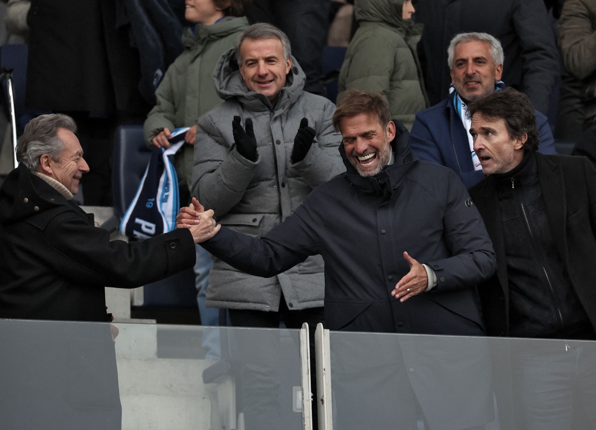 German football trainer and global head of Football at Red Bull, Jurgen Klopp (front 2ndR) shakes hands with French journalist and writer Michel Denisot (L) next to representative of the Agache family holding company Antoine Arnault at the end of the French Digue 2 football match between Paris football Club (PFC) and Amiens at Stade Charley in Paris, on January 11, 2025. (Photo by FRANCK FIFE / AFP)
