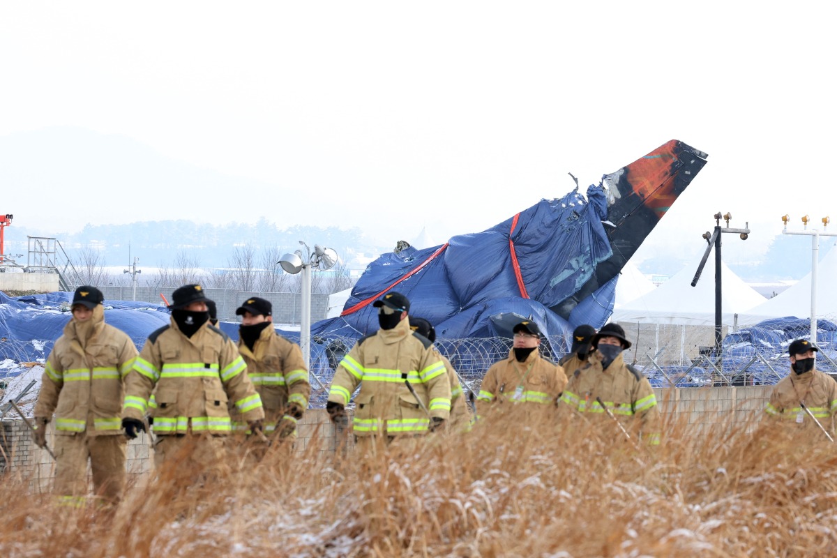 Firefighters take part in a search operation near the site where a Jeju Air Boeing 737-800 aircraft crashed and burst into flames at Muan International Airport in Muan, some 288 kilometres southwest of Seoul on January 11, 2025. Photo by YONHAP / AFP