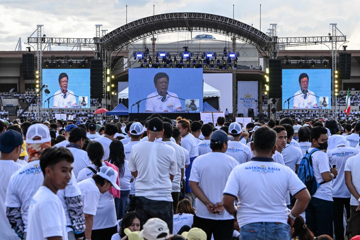 Members of the influential sect Iglesia ni Cristo (Church of Christ) watch Philippine lawmaker Rodante Marcoleta speak as they attend a rally to oppose calls to unseat Vice-President Sara Duterte in Manila on January 13, 2025. (Photo by JAM STA ROSA / AFP)