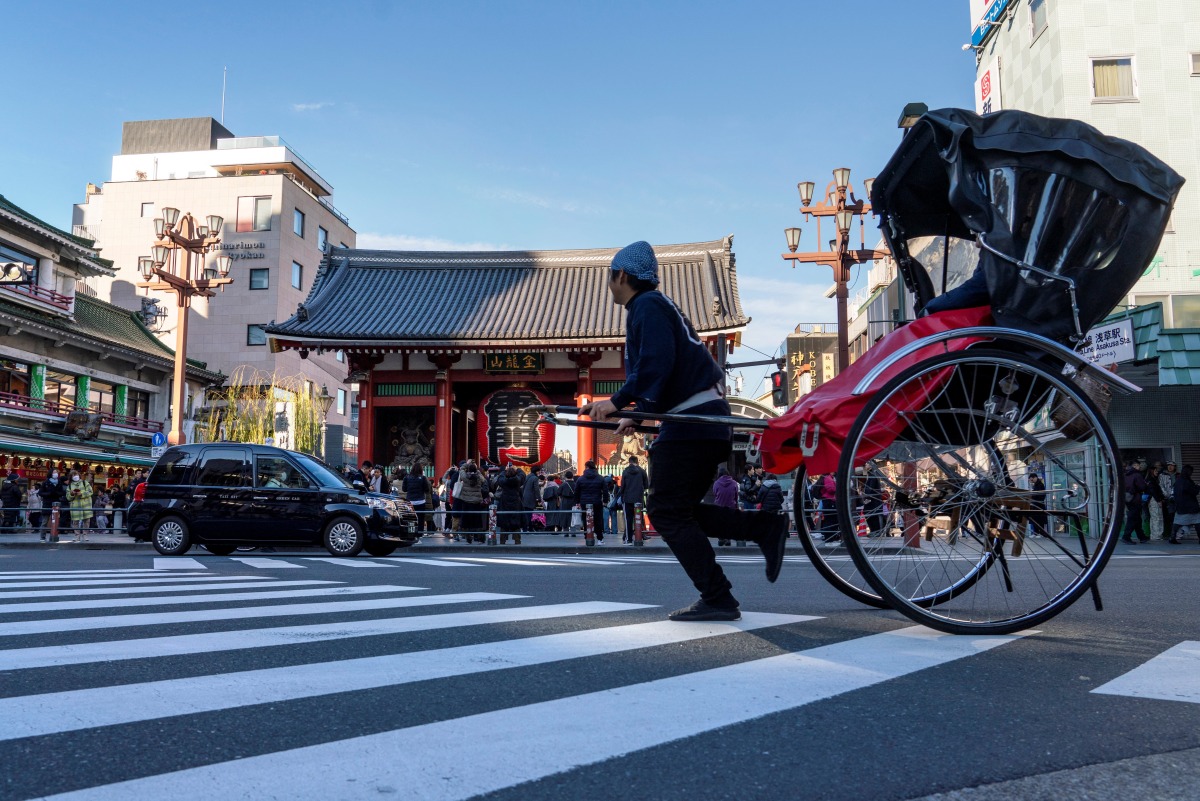 A rickshaw carrying a tourist drives down the street in front of Sensoji Temple in Asakusa, Tokyo on January 14, 2025. Photo by Kazuhiro NOGI / AFP