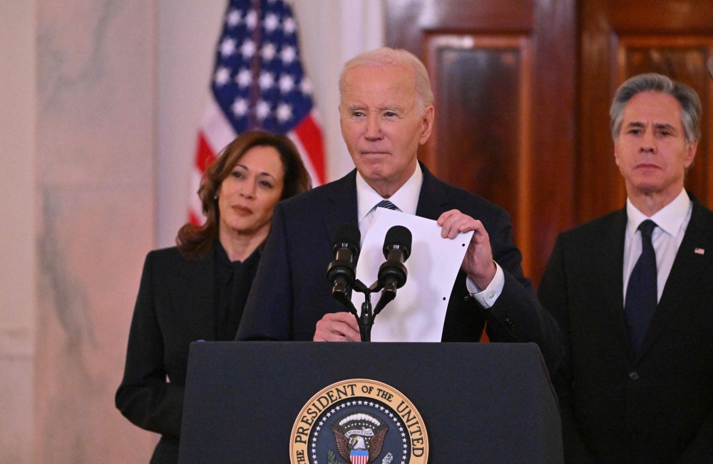 US President Joe Biden, flanked by Vice President Kamala Harris and Secretary of State Antony Blinken, speaks about the Israel-Hamas ceasefire and hostage release deal in the Cross Hall of the White House on January 15, 2025. (Photo by Roberto Schmidt / AFP)