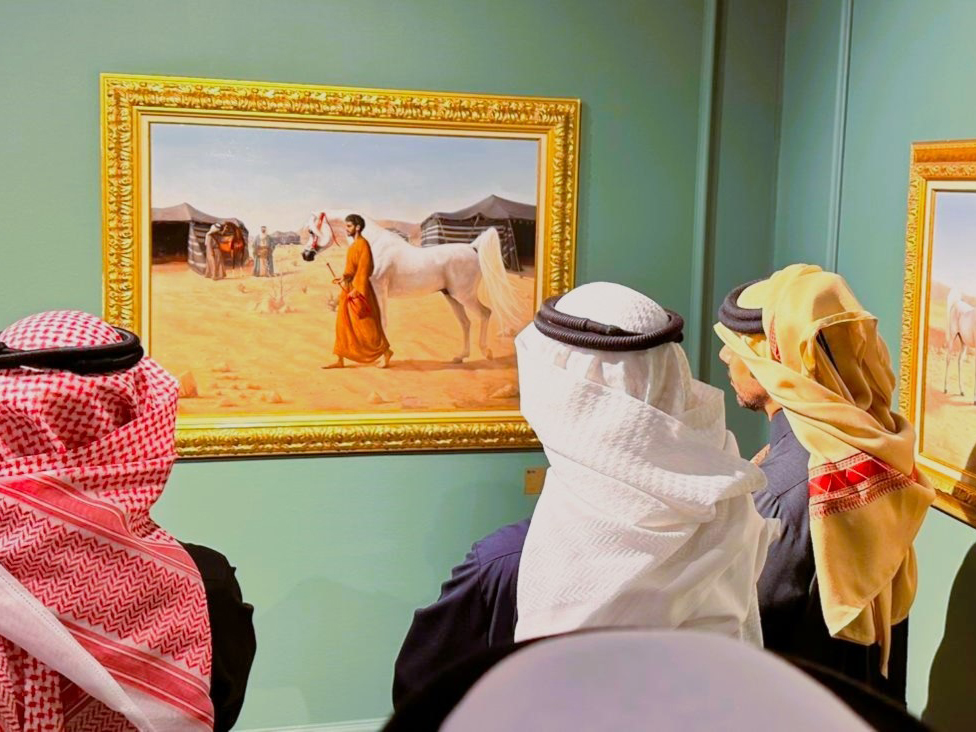 Visitors look at the artworks on display.