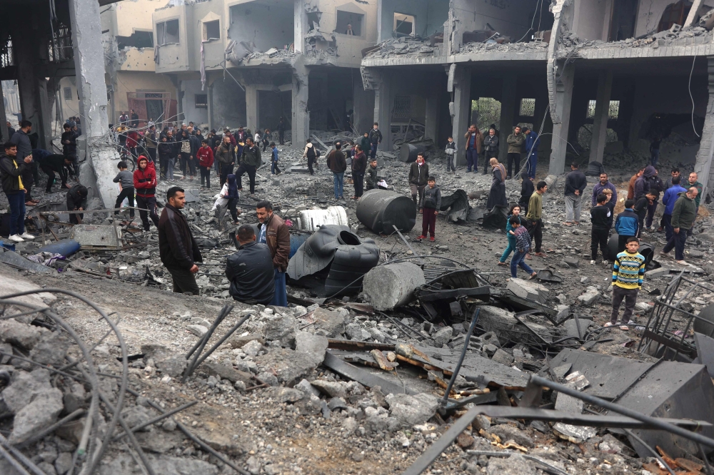 People check the rubble of buildings hit in Israeli strikes the previous night in Jabalia in the northern Gaza Strip, on January 16, 2025. (Photo by Omar Al-Qattaa / AFP)