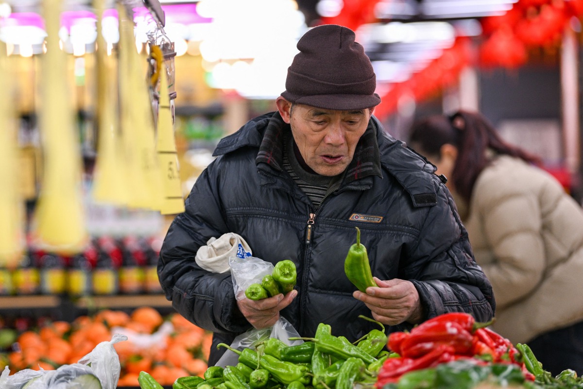 A customer picks vegetables at a supermarket in Nanjing, east China's Jiangsu province on January 17, 2025. Photo by AFP