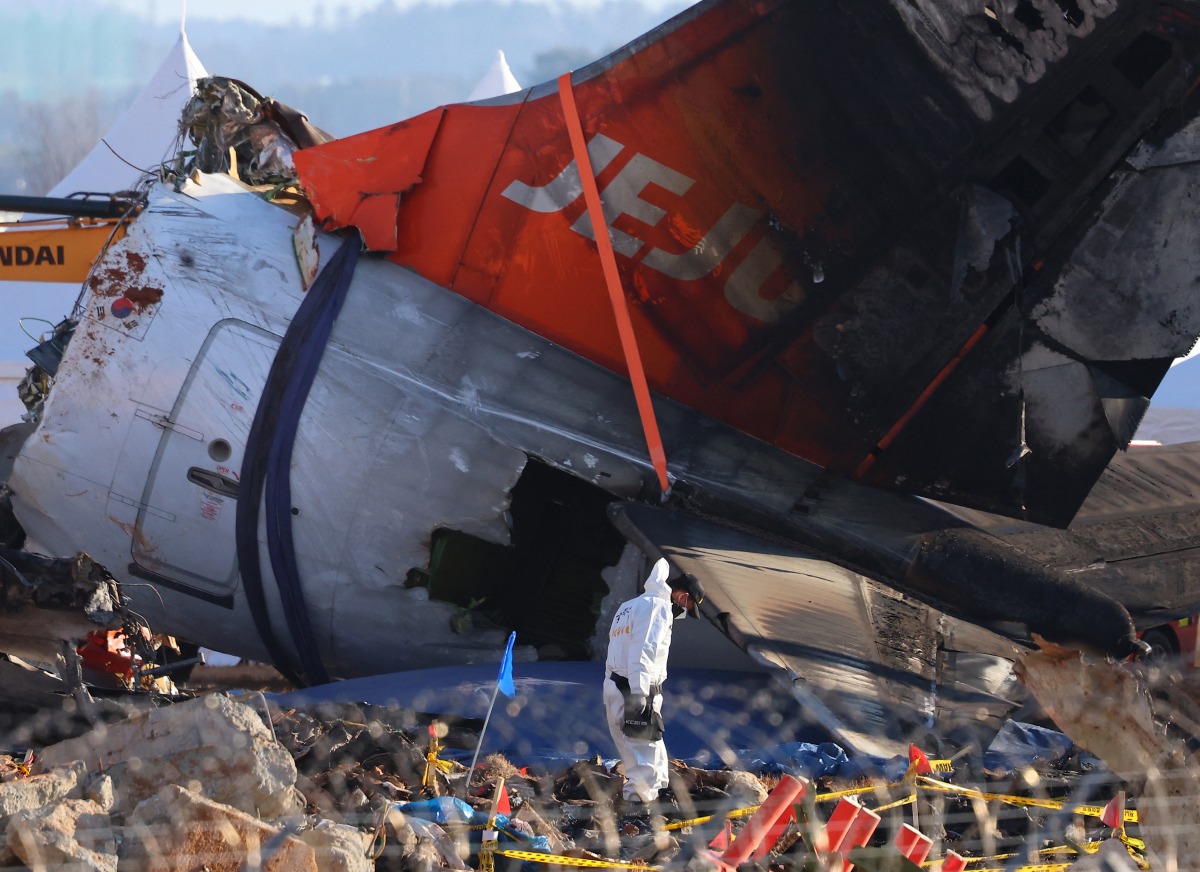 Investigators and emergency response personnel work at the site where a Jeju Air Boeing 737-800 aircraft crashed and burst into flames at Muan International Airport in Muan, some 288 kilometres southwest of Seoul on January 4, 2025. Photo by YONHAP / AFP

