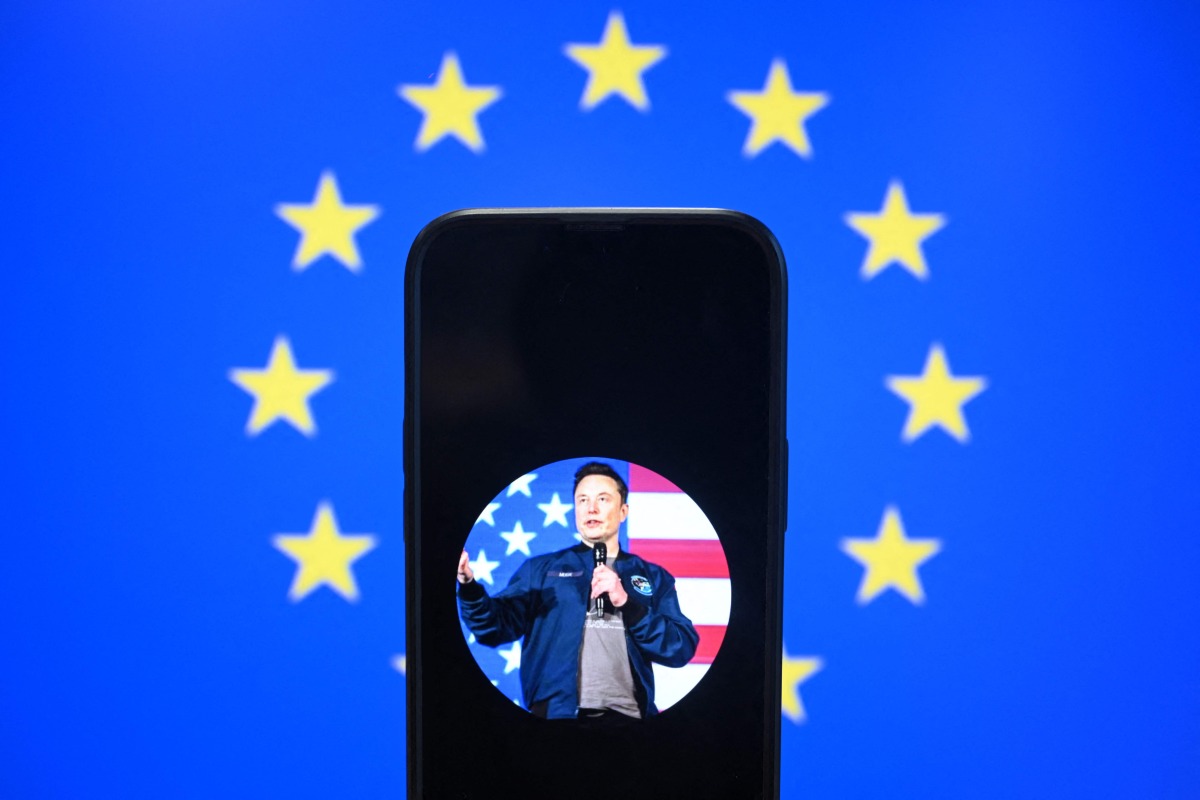 This illustration photograph shows Elon Musk's X (formerly Twitter) account displayed on a smartphone in front a European Union flag in Brussels on January 7, 2025. Photo by Nicolas TUCAT / AFP