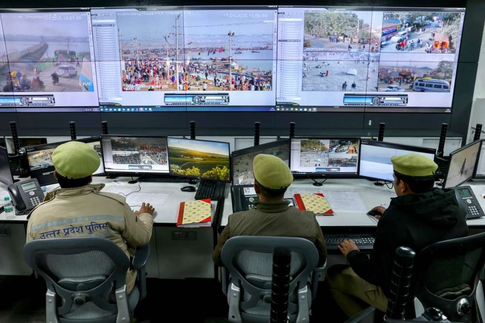 Police monitor the situation via screens at the Integrated Command and Control Center during the Maha Kumbh Mela festival in Prayagraj on January 17, 2025. (Photo by Niharika Kulkarni / AFP) 