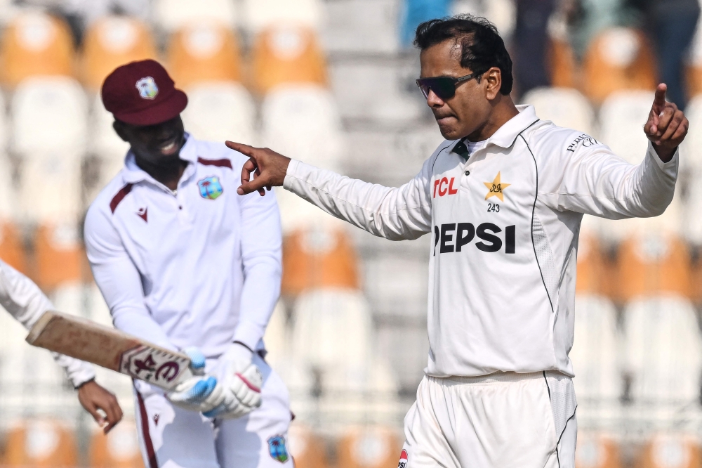 Pakistan's Noman Ali celebrates after taking the wicket of West Indies' Kevin Sinclair (L) during the second day of the first Test cricket match between Pakistan and West Indies at the Multan Cricket Stadium in Multan on January 18, 2025. (Photo by Aamir QURESHI / AFP)