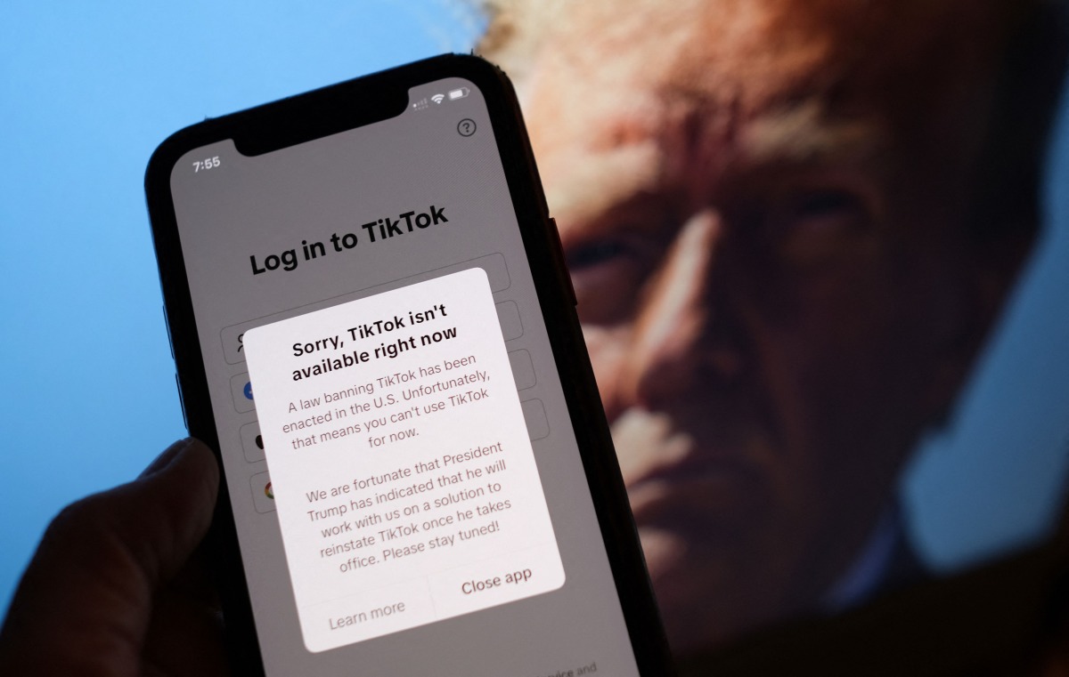 This illustration photo taken in Los Angeles on January 18, 2025, shows the TikTok app on a smartphone screen in front of a photo of US President-elect Donald Trump. Photo by Chris Delmas/ AFP