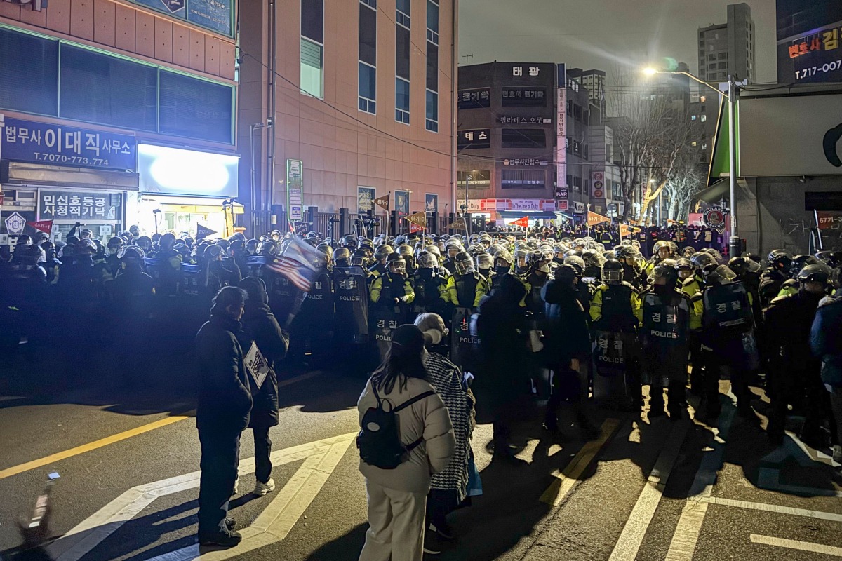 Police stand guard on a street near the Seoul Western District Court in Seoul, early on January 19, 2025, after hundreds of pro-Yoon protesters smashed windows and broke down doors to enter the court following the extension of the detention of impeached South Korea President Yoon Suk Yeol. Photo by Jin-kyu Kang / AFP