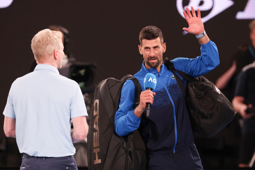 Serbia's Novak Djokovic (R) speaks into the microphone on court after winning his men's singles match against Czech Republic's Jiri Lehecka in Melbourne on January 19, 2025. (Photo by David Gray / AFP)