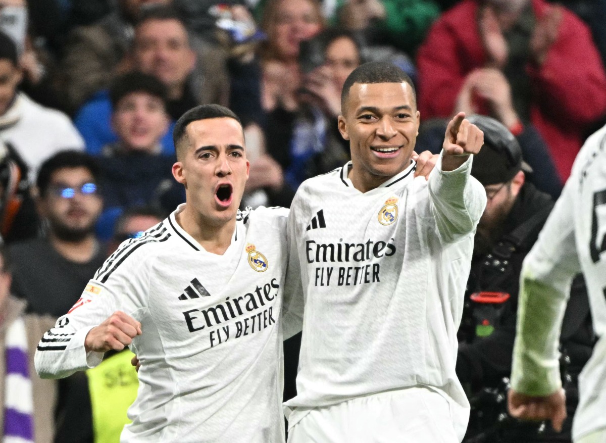 Real Madrid's French forward #09 Kylian Mbappe celebrates scoring his team's third goal with Real Madrid's Spanish defender #17 Lucas Vazquez during Spanish league football match between Real Madrid CF and UD Las Palmas at the Santiago Bernabeu stadium in Madrid on January 19, 2025. (Photo by JAVIER SORIANO / AFP)
