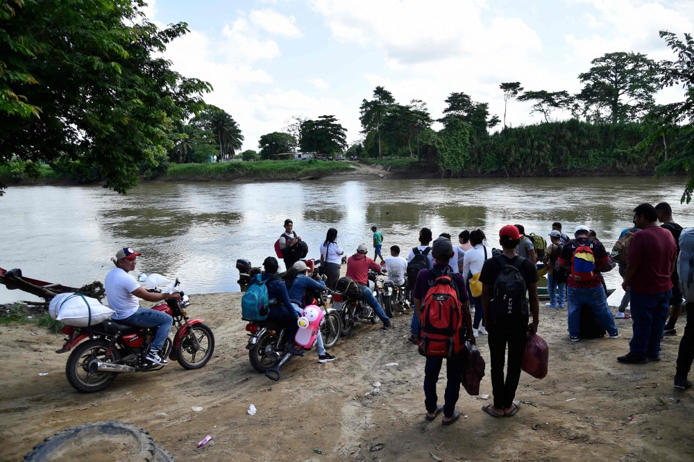 Displaced people from recent clashes between armed groups wait to cross the Tarra River, which divides Colombia and Venezuela, in Tibu, Norte de Santander department, Colombia, on January 19, 2025. (Photo by Schneyder Mendoza / AFP)