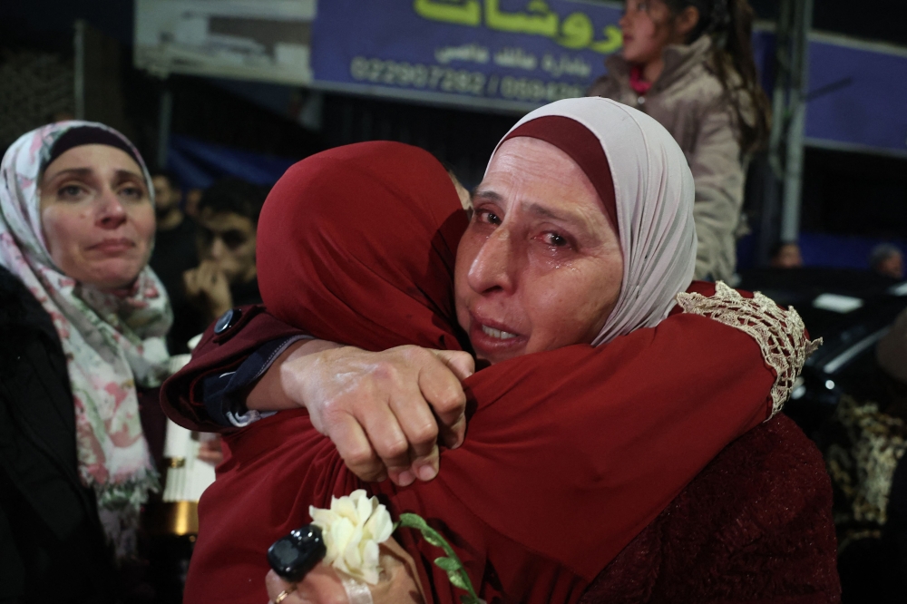 A Palestinian woman cries as she embraces a loved one who was released from Israeli jail in the early hours of January 20, 2025. (Photo by Zain Jaafar / AFP)