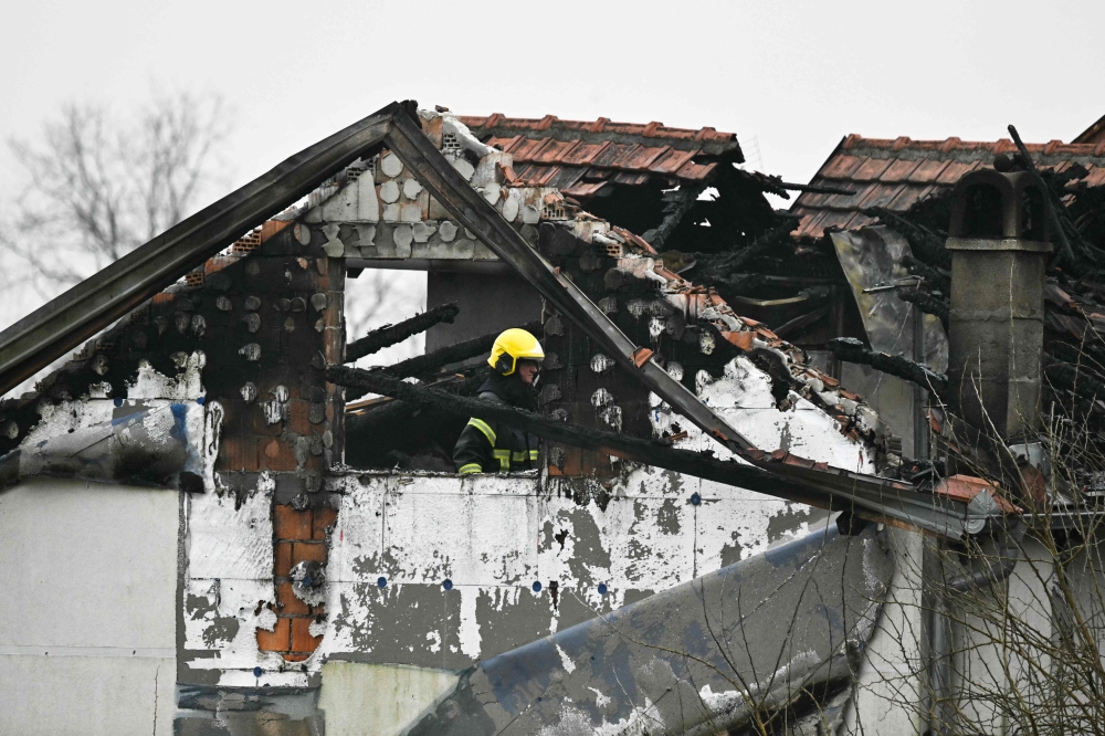 A fireman inspects damages caused by a fire at a retirement home, on the outskirts of Serbia's capital Belgrade on January 20, 2025. (Photo by Andrej Isakovic / AFP)